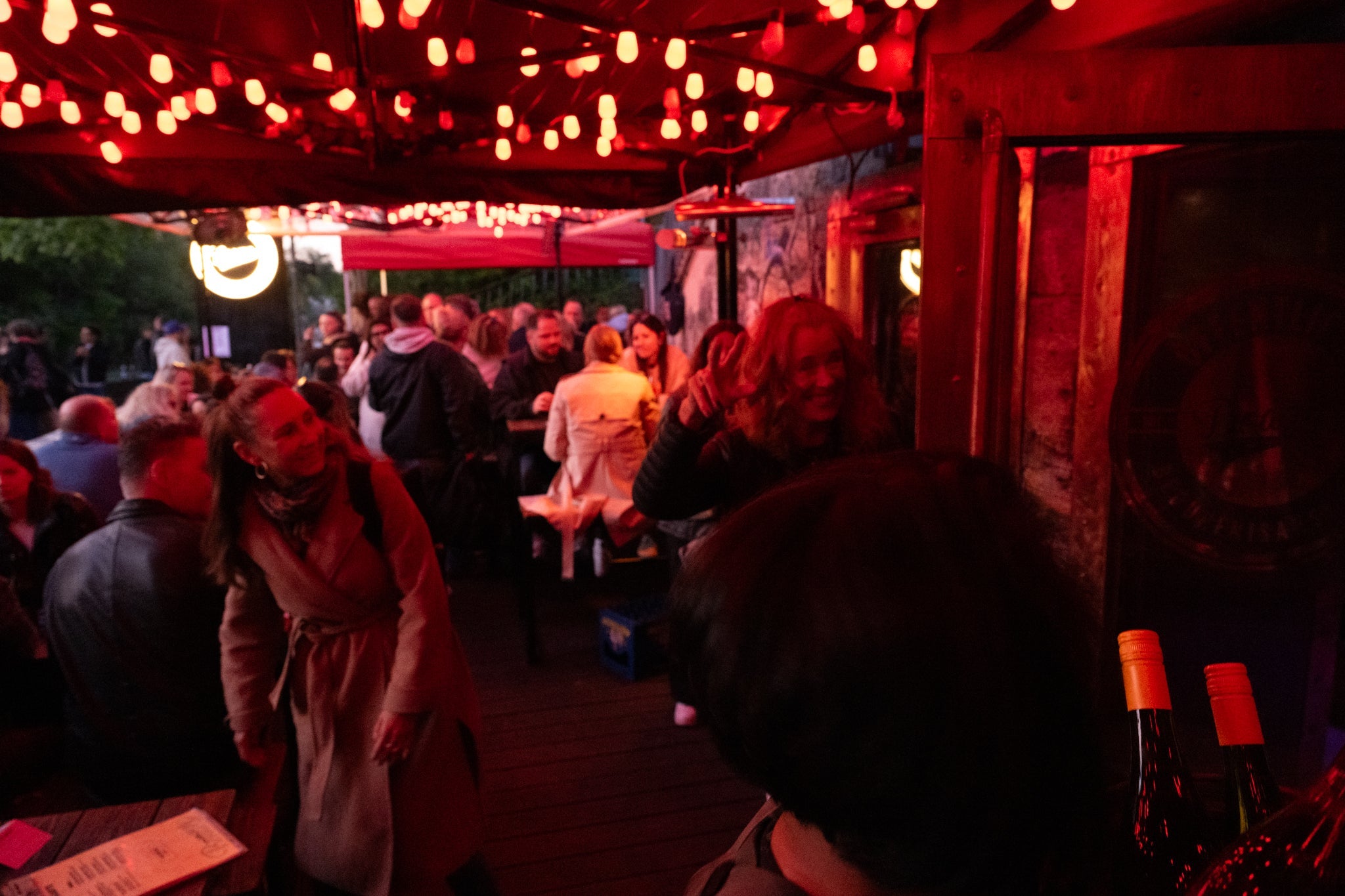 Volle Boazn-Terrasse am Abend unter roter Lichterkette — Bar in Au-Haidhausen München an der Isar