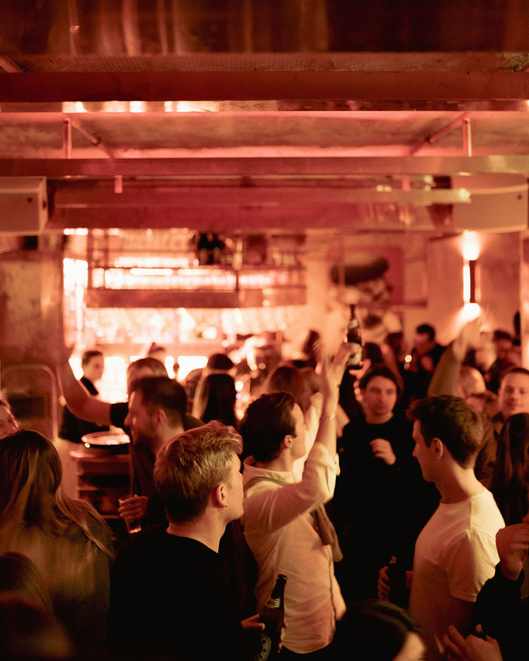 Volle Boazn von innen, Gäste heben Bierflaschen unter warmem Deckenlicht – Bar in München, Januar 2026