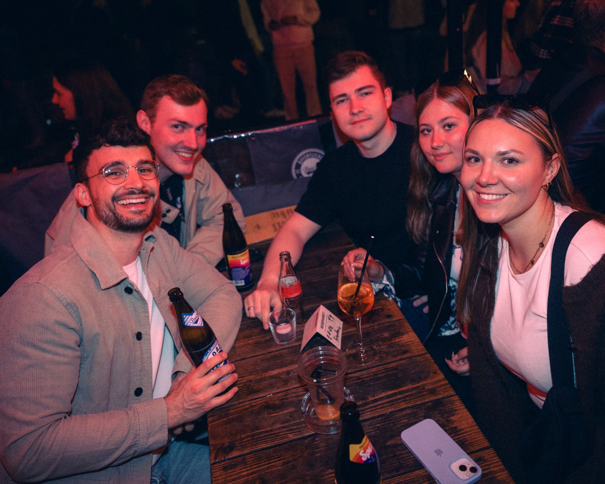 Fünfergruppe am Tisch in der Boazn München mit Eigenbier und Drinks — eine der angesagtesten Bars laut VorOrth