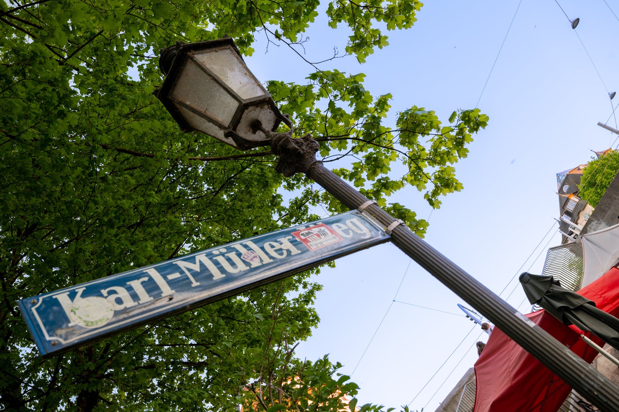 Straßenschild Karl-Müller-Weg vor der Boazn an der Ludwigsbrücke in München