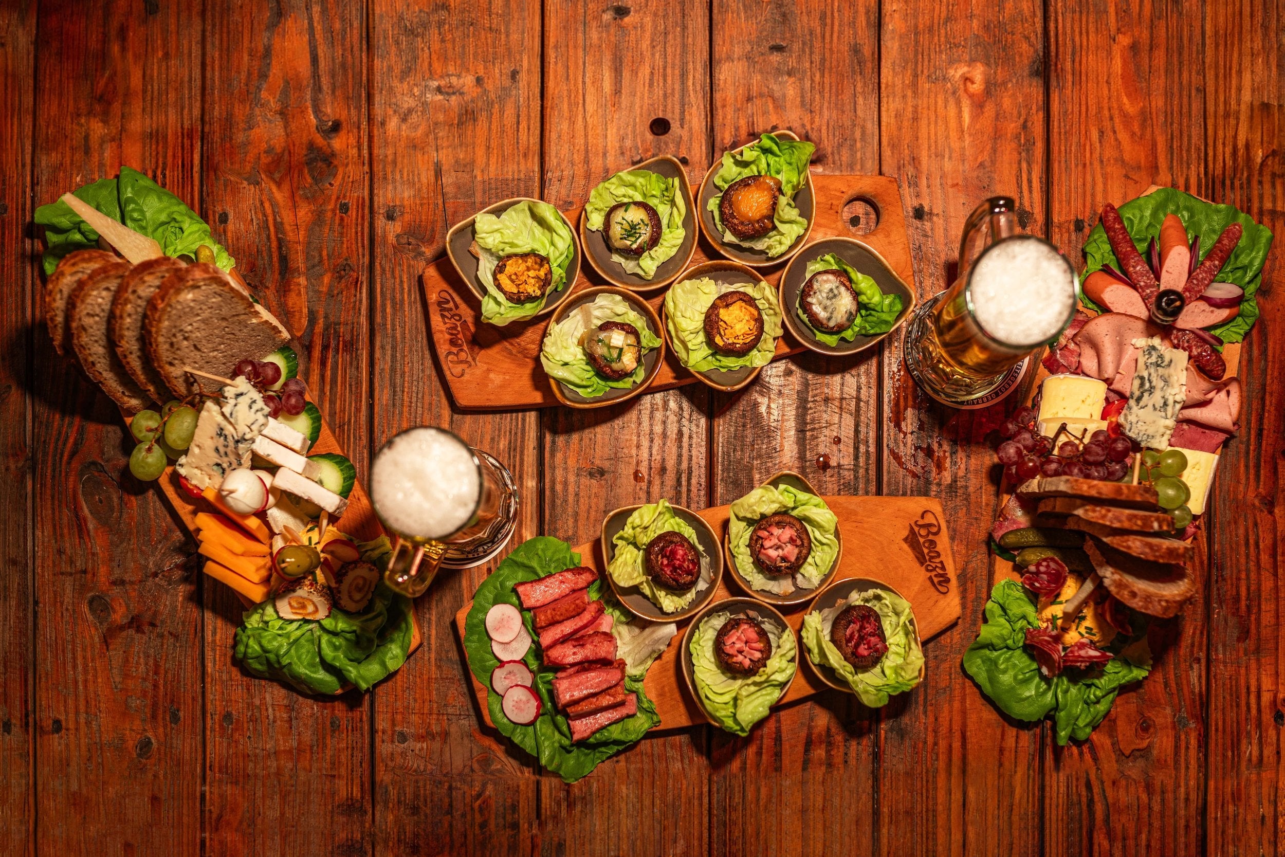 Boazn-Brotzeitplatte mit Pinsa, Käse, Wurst und Hellem Bier — Speisekarte der Boazn München