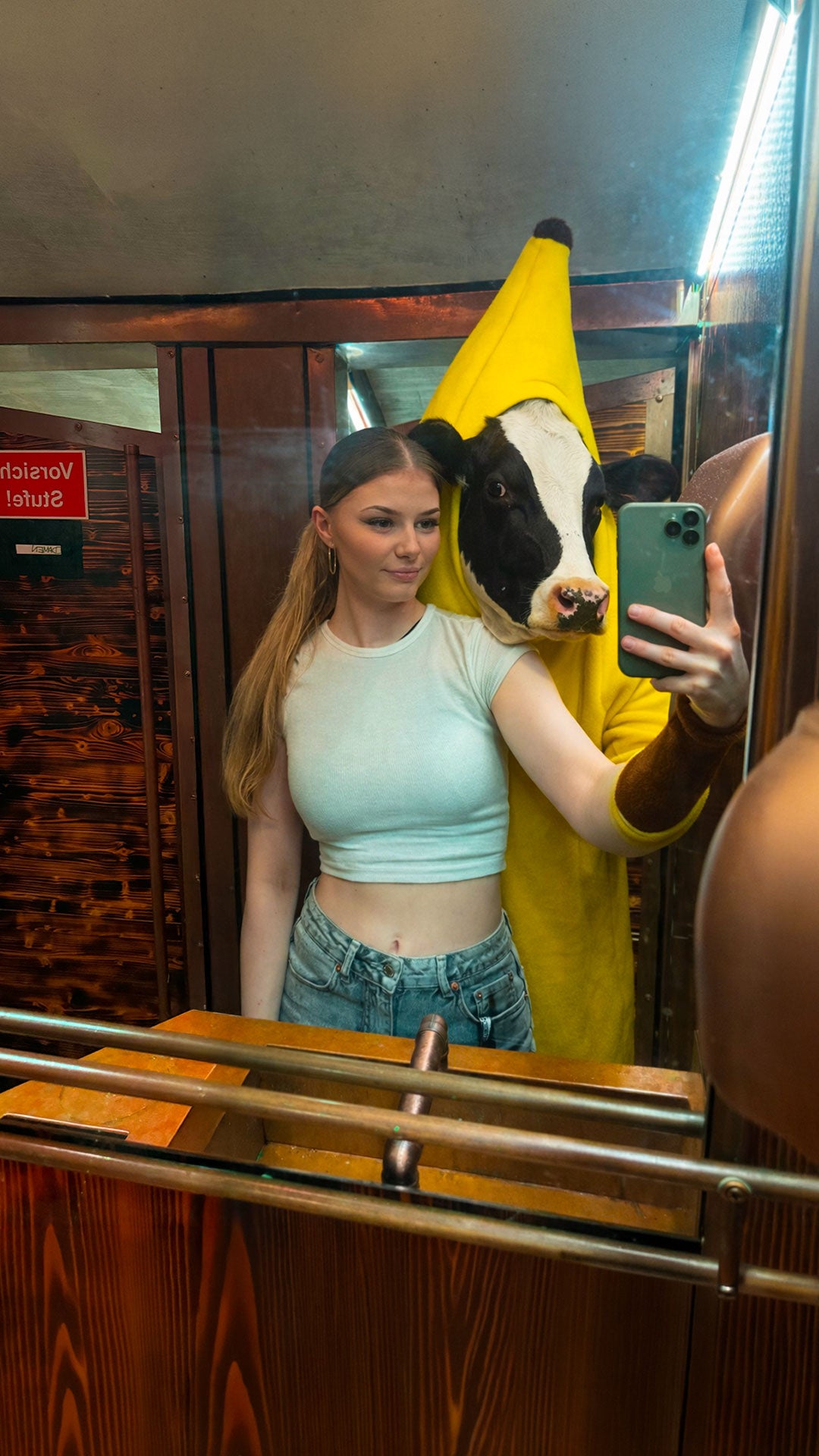 Junge Frau macht Spiegel-Selfie neben Freund im Bananenkostüm mit Kuh-Maske – kuriose Boazn-Momente, Januar 2026 3