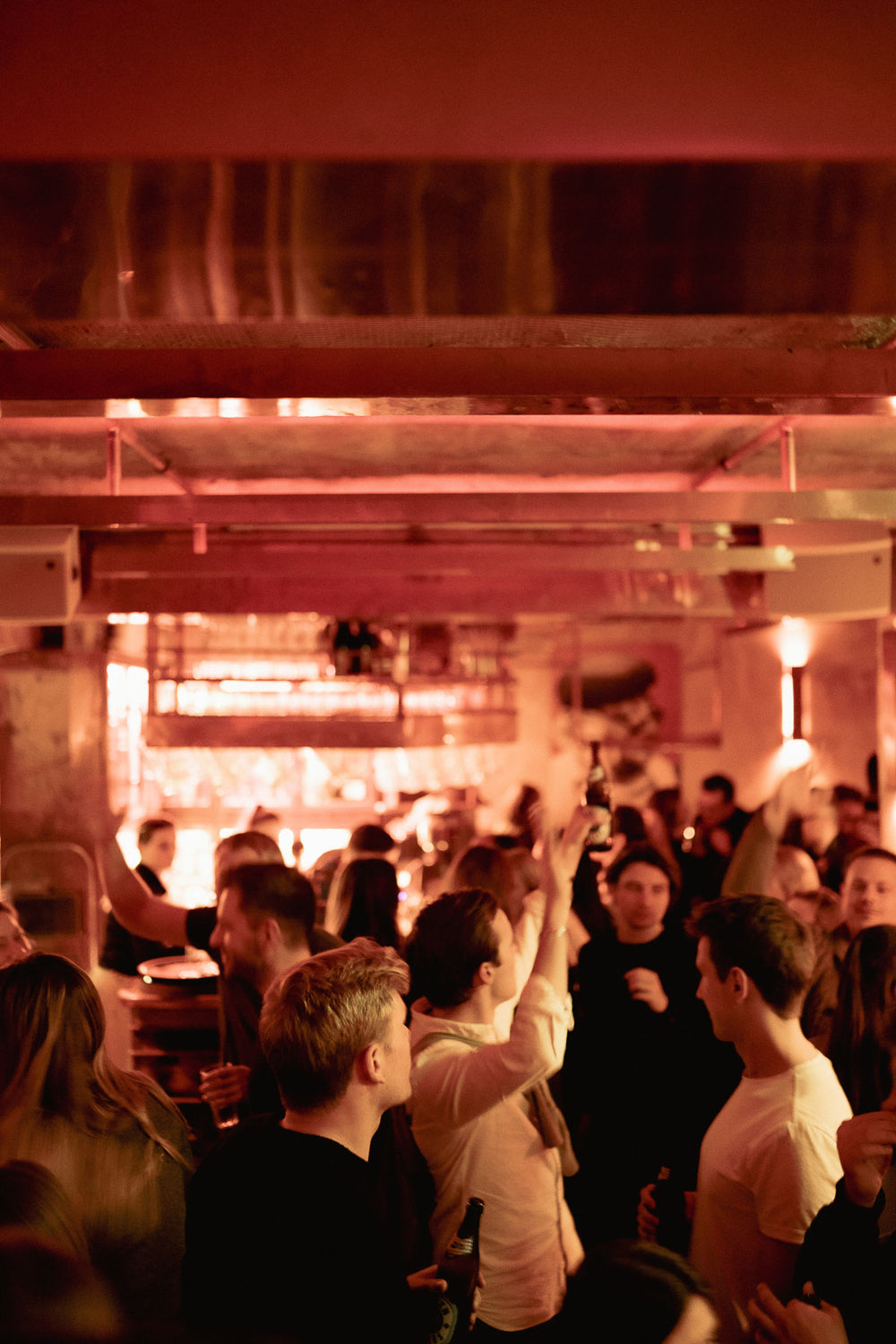 Volle Boazn Bar in München bei roter Beleuchtung, Gäste tanzen und feiern auf der Tanzfläche