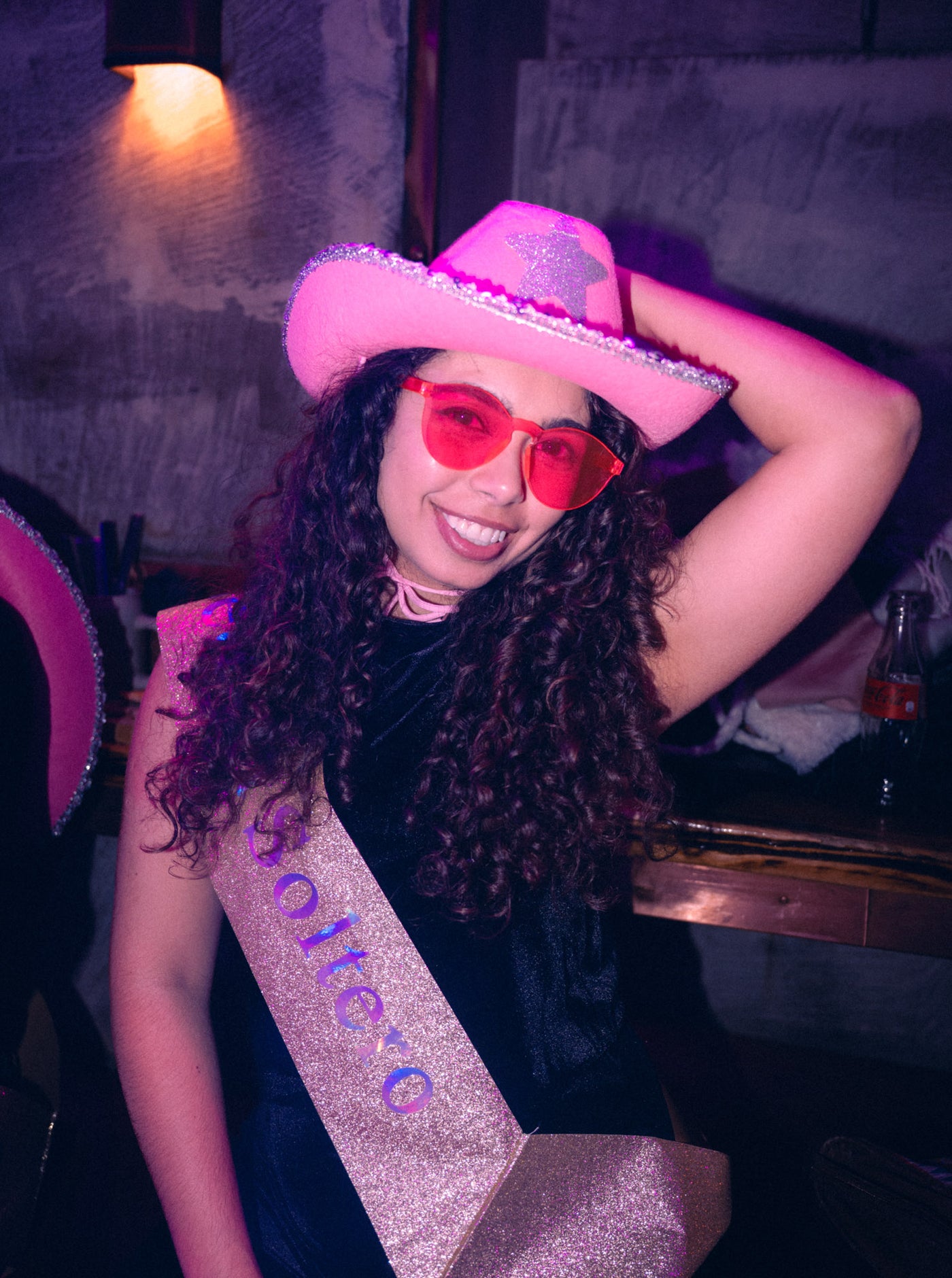 Frau mit pinkem Cowboyhut, roter Brille und „Soltera“-Schärpe lacht – JGA in der Boazn München, März 2026 6
