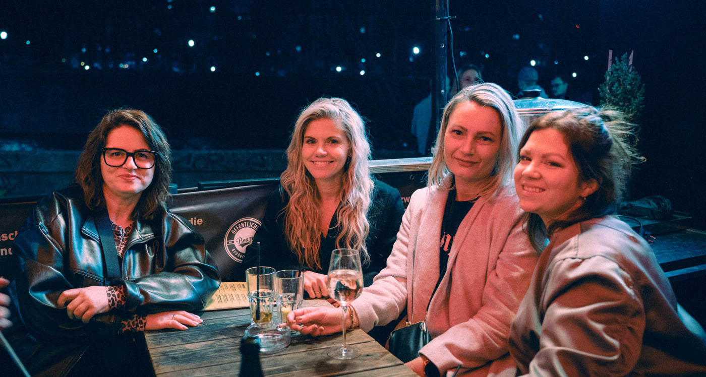 Vier Freundinnen lachen am Tisch mit Weißweingläsern auf der Boazn-Terrasse – Nightlife München, Januar 2026 7