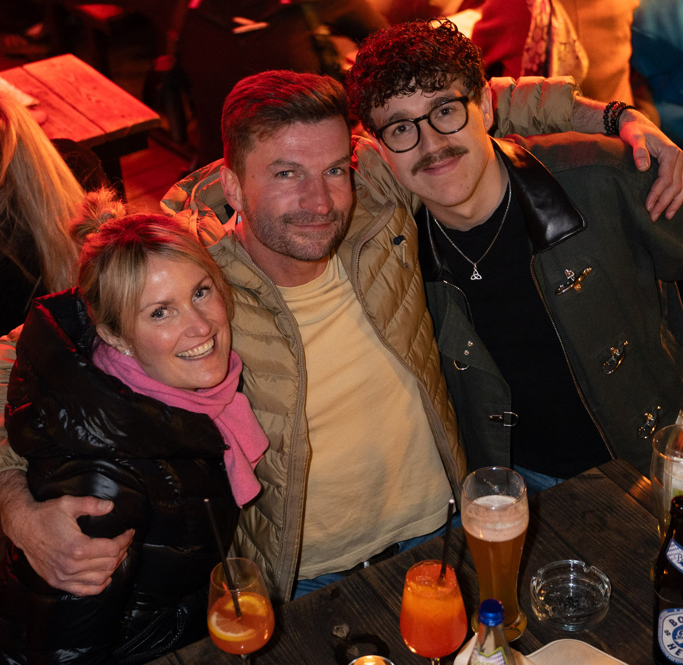 Drei Freunde lachen herzhaft am Tisch mit Bier und Aperol-Spritz – Bar an der Ludwigsbrücke, Januar 2026 9
