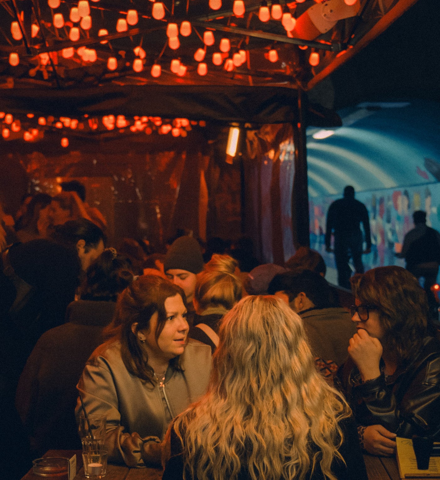Boazn-Terrasse mit Lichterketten, Gäste sitzen am Tisch, Ludwigsbrücken-Tunnel im Hintergrund – Bar in München, Februar 2026 28