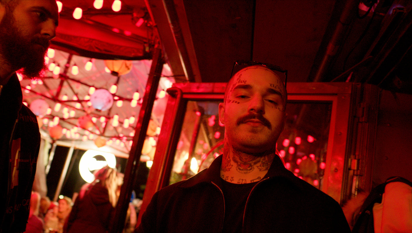 Gast mit Gesichtstattoos vor rot leuchtenden Lichterketten – Halloween 2025, Nightlife München 13