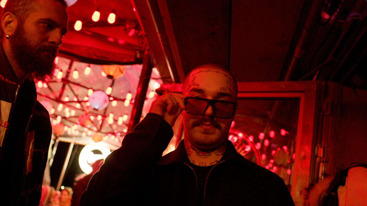 Gast setzt seine Sonnenbrille auf, Lichterketten im Hintergrund – Halloween 2025 in der Boazn München 14