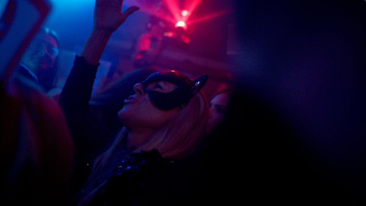 Gast mit Katzenmaske streckt den Arm zur Musik – Halloween 2025, Tanzbar an der Isar 36