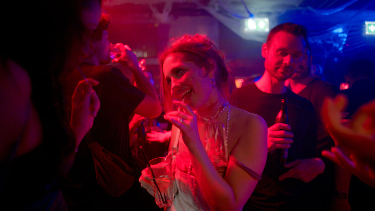 Gast mit Glas in der Hand lacht im roten Licht – Halloween 2025, Boazn München 40