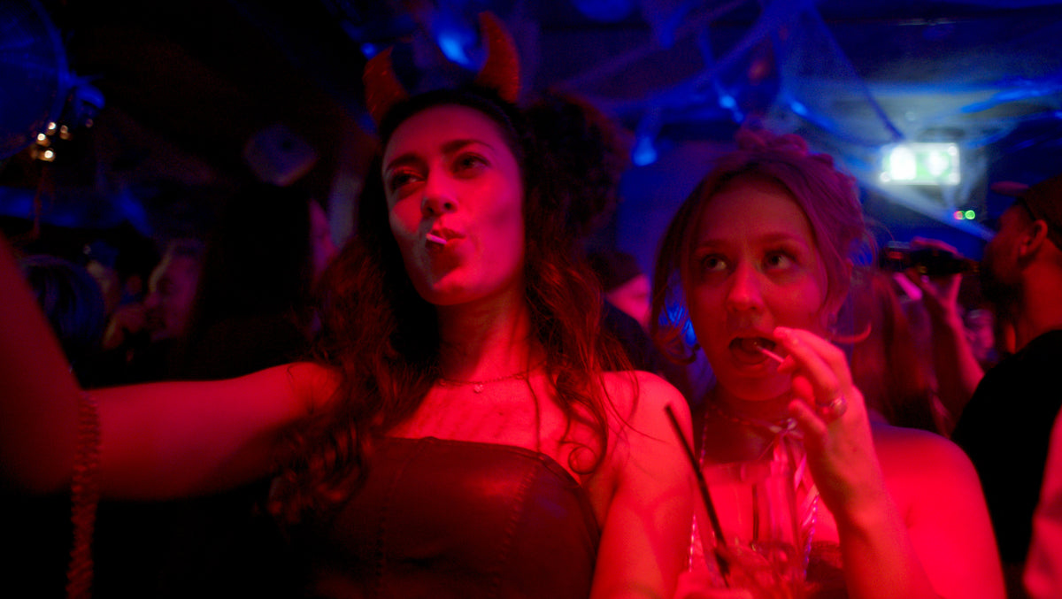 Zwei Gäste, eine mit Teufelshörnern, im roten Licht – Halloween 2025, Nightlife München 41