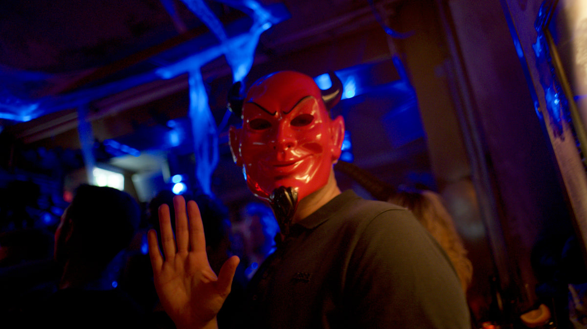 Gast mit roter Teufelsmaske unter Deko-Spinnweben – Halloween 2025 in der Boazn München 45