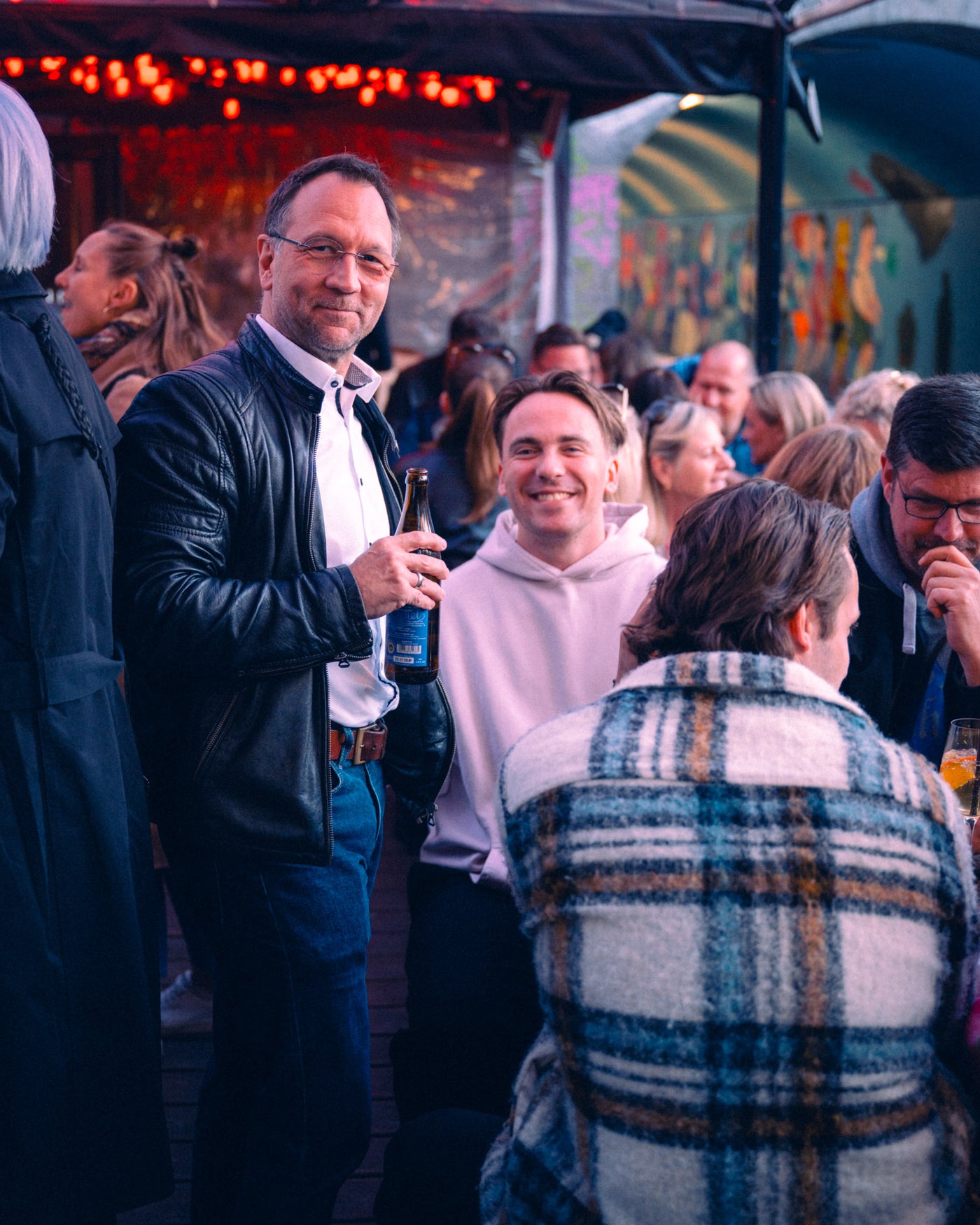 Gast lächelt mit Augustiner Helles in der Hand – Boazn München, Bar an der Isar, April 2026 2