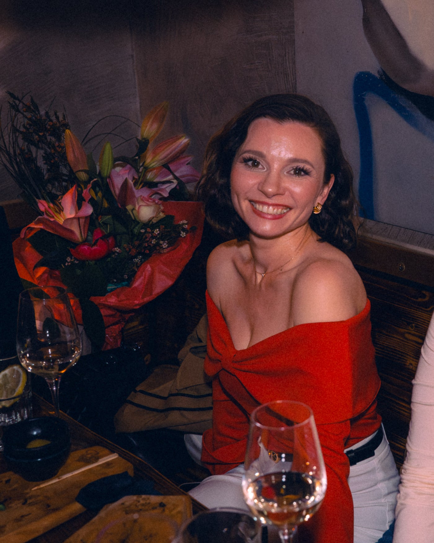 Frau im roten Kleid mit Blumenstrauß bei einer Geburtstagsfeier – Boazn München, April 2026 6
