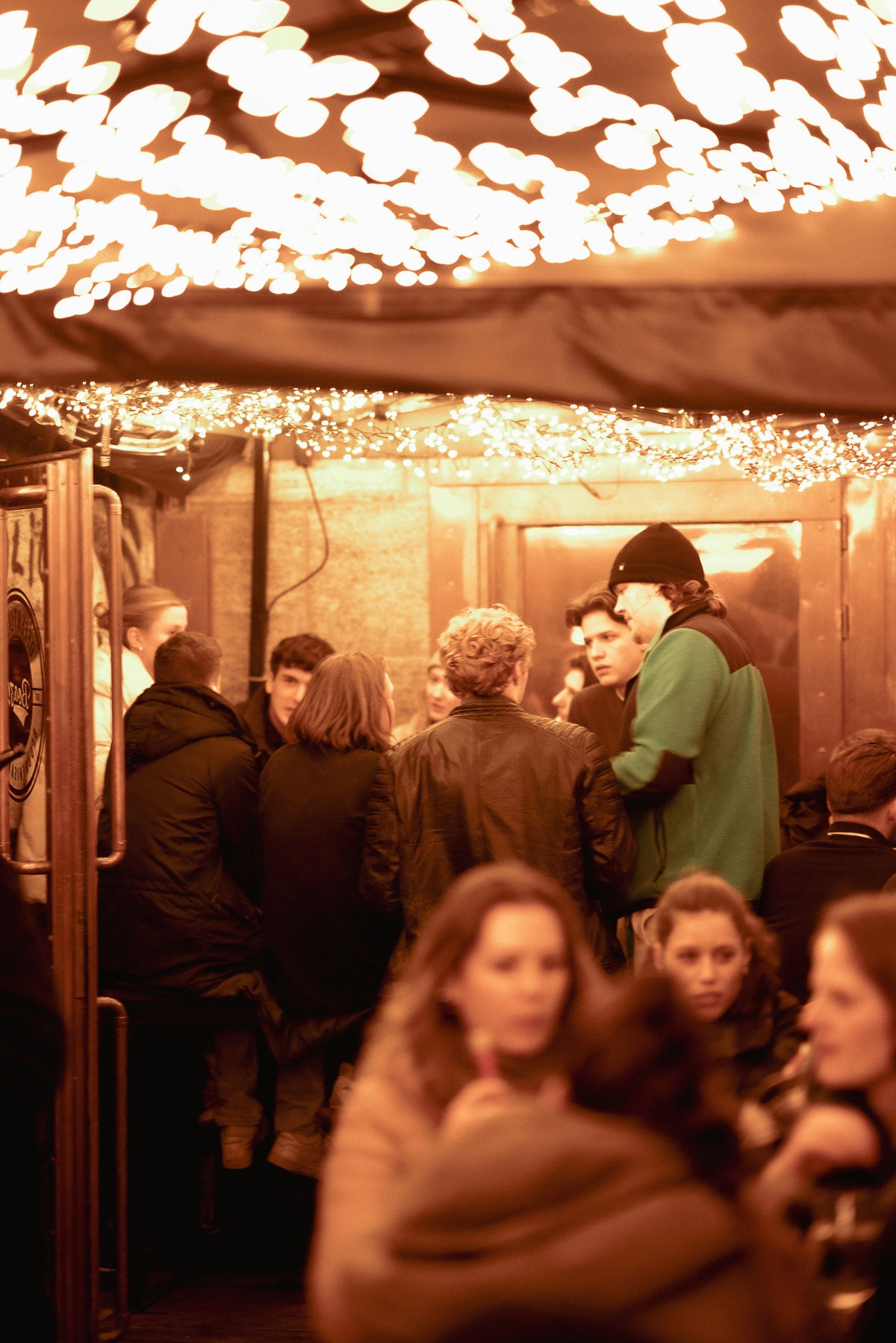 Eingangsbereich der Boazn mit dichten Lichterketten und Gästen – Tanzbar an der Ludwigsbrücke, München, Dezember 2025 14