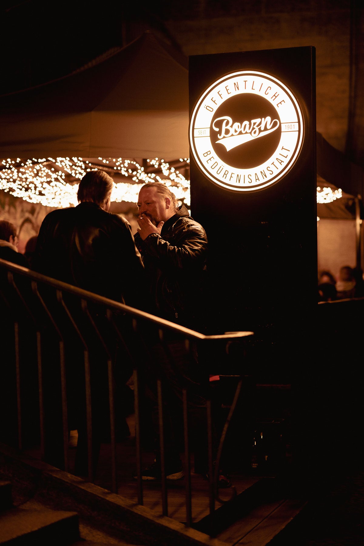 Beleuchtetes Boazn-Logo am Eingang bei Nacht – Bar unter der Ludwigsbrücke, München, Dezember 2025 18