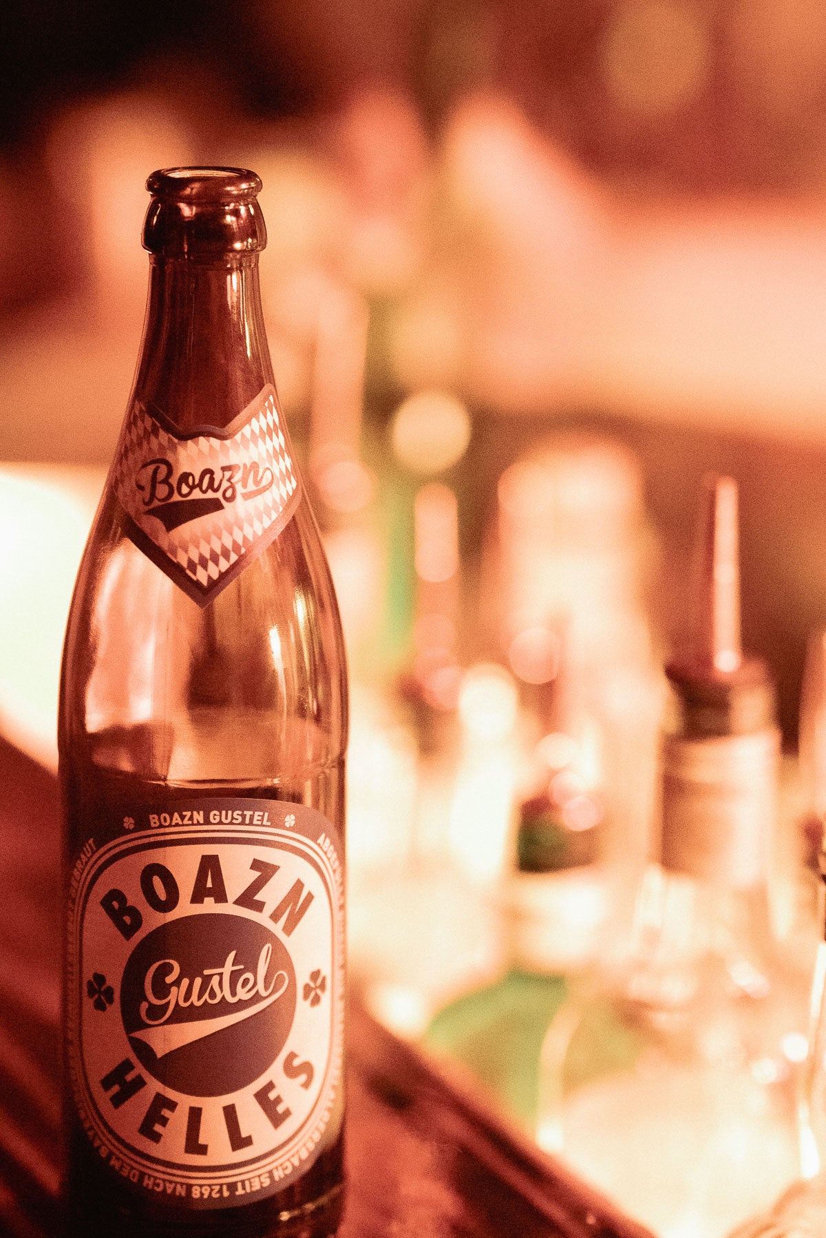 Boazn Gustel Helles vor dem Spirituosen-Regal hinter der Bar – Eigenbier der Boazn München, Dezember 2025 36