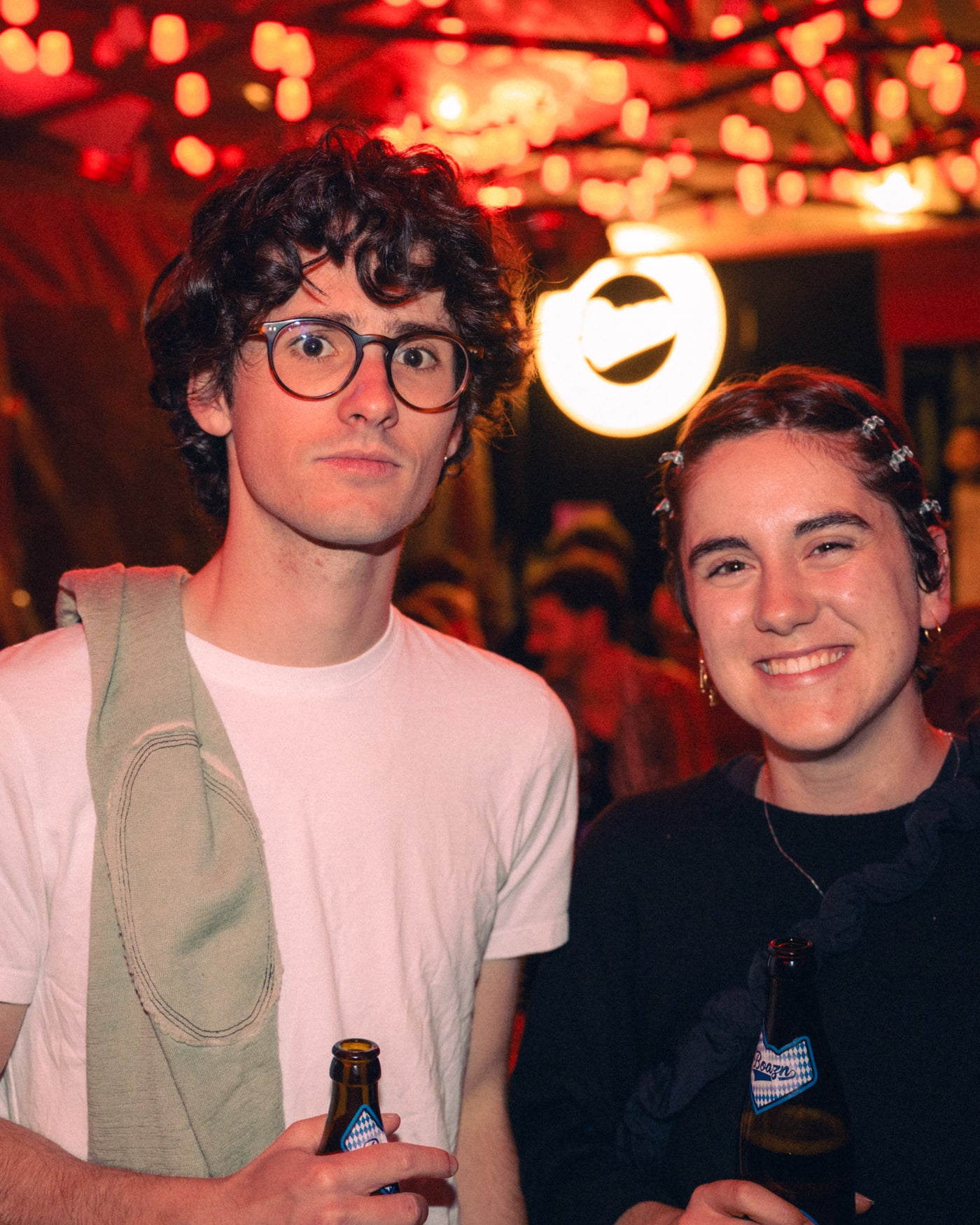Junges Paar mit Brillen und Boazn Helles in der Hand – Boazn München, Bar an der Ludwigsbrücke, Mai 2026 15