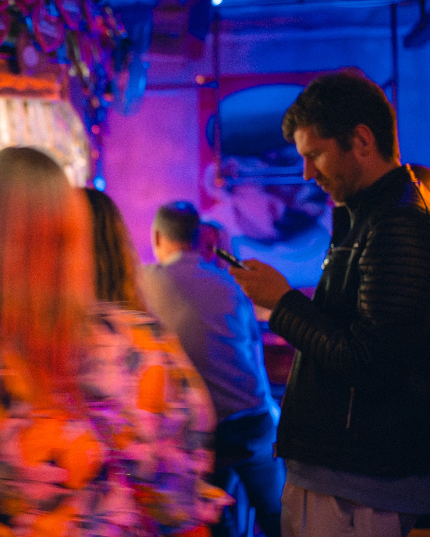 Stimmungsvolle Innenraum-Szene in blau-violettem Licht, Gast am Handy – Boazn München, Tanzbar an der Ludwigsbrücke, Mai 2026 20