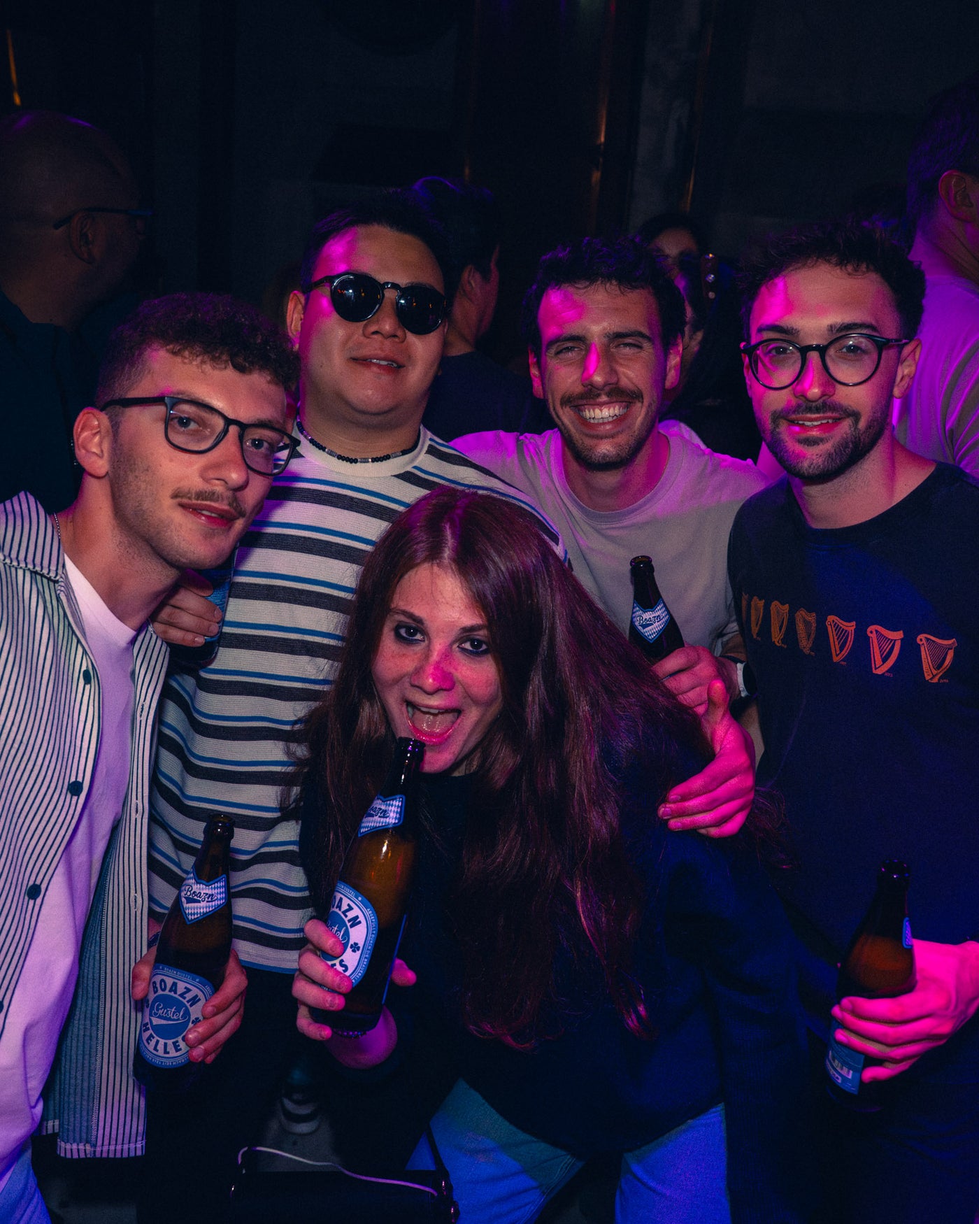 Fünf Freunde mit Boazn-Helles-Flaschen im pinken Discolicht – Boazn München, Nightlife an der Ludwigsbrücke, Mai 2026 28