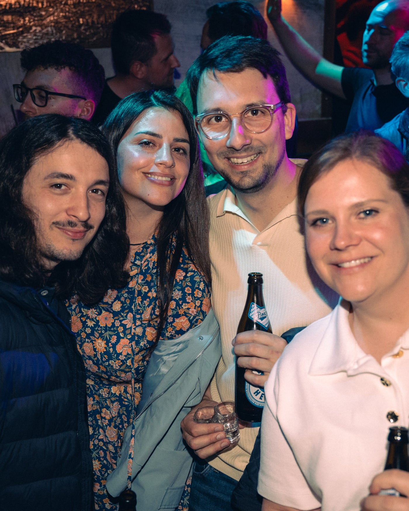 Vierergruppe lacht mit Augustiner-Edelstoff im pinken Licht – Boazn München, Bar an der Isar, Mai 2026 39