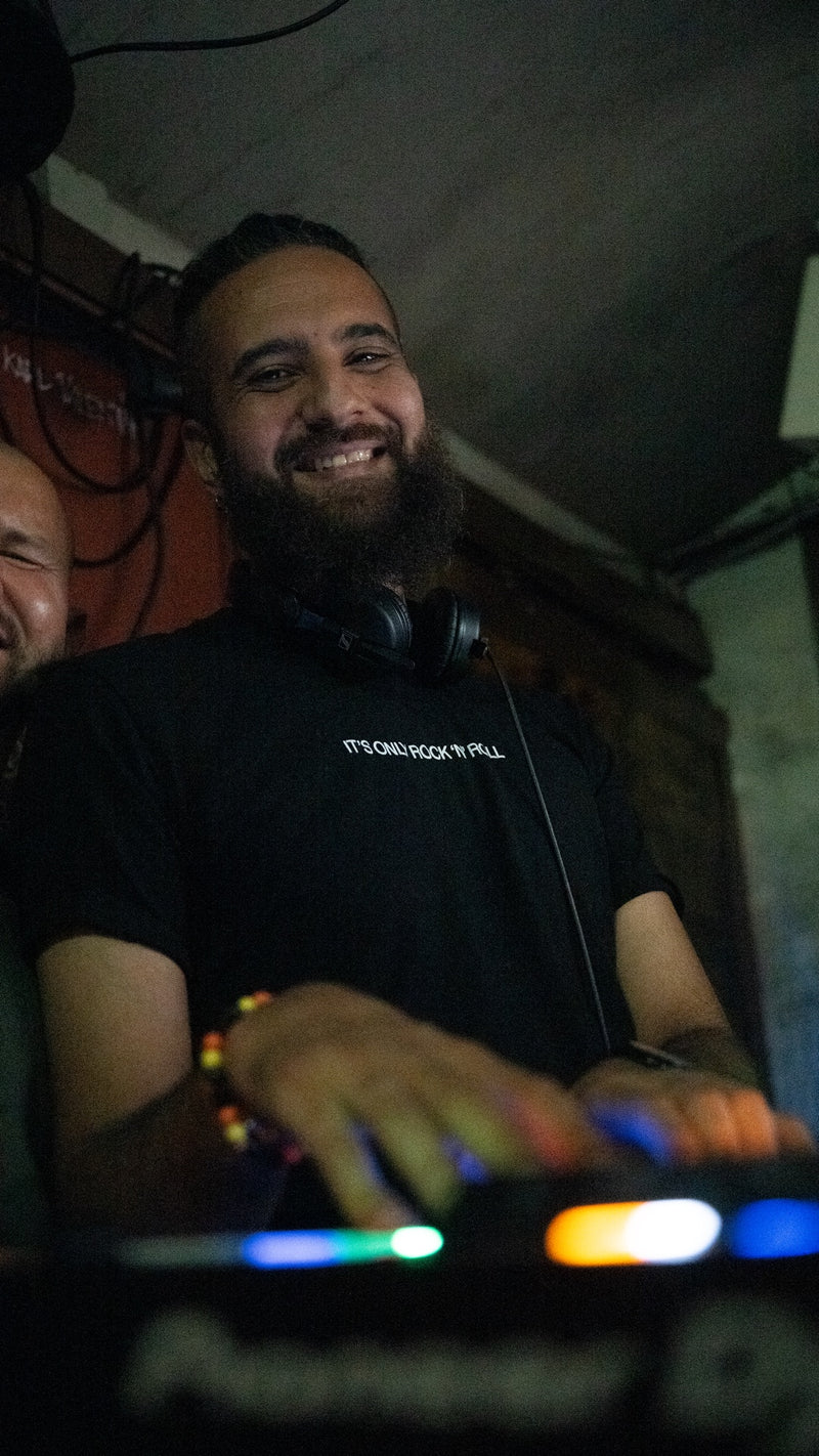 Mel am DJ-Pult in der Boazn München, lachend mit Kopfhörern um den Hals – Münchner Dance- und House-DJ